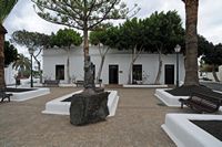 A cidade de Yaiza em Lanzarote. Mulher com jarro e Casa da Cultura, Praça dos Remédios. Clicar para ampliar a imagem.