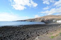 A aldeia de Playa Quemada em Lanzarote. As praias de Quemada e da Arena e na distância, fazendas de peixes. Clicar para ampliar a imagem em Adobe Stock (novo guia).