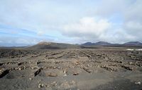 Het dorp Uga in Lanzarote. De wijngaarden van Uga aan de voet van Montaña del Chupadero. Klikken om het beeld te vergroten in Adobe Stock (nieuwe tab).