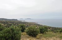 Le village d’Agios Pavlos en Crète. La plage de Triopétra, le cap Mélissa et les îles Paximadia vus depuis Drimiskos. Cliquer pour agrandir l'image.